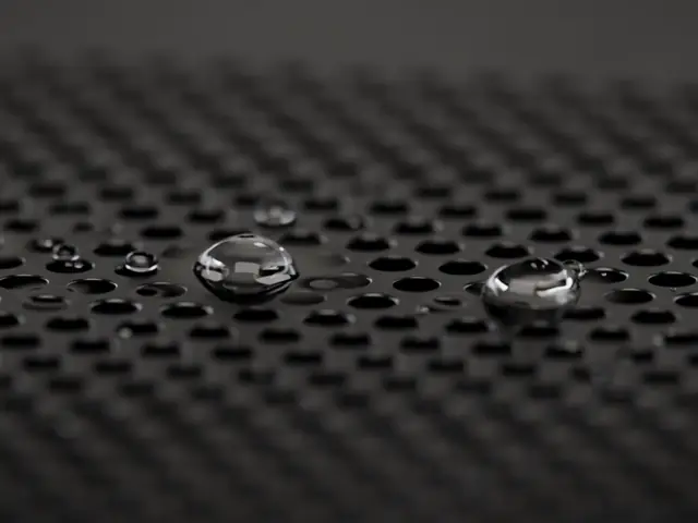 A few small water droplets left behind on a metal speaker grille